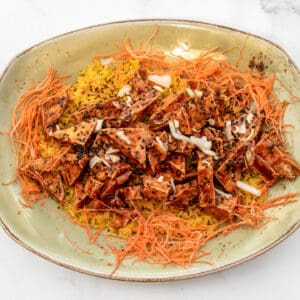 Spicy Korean chicken stir-fry with shredded carrots and sesame seeds.